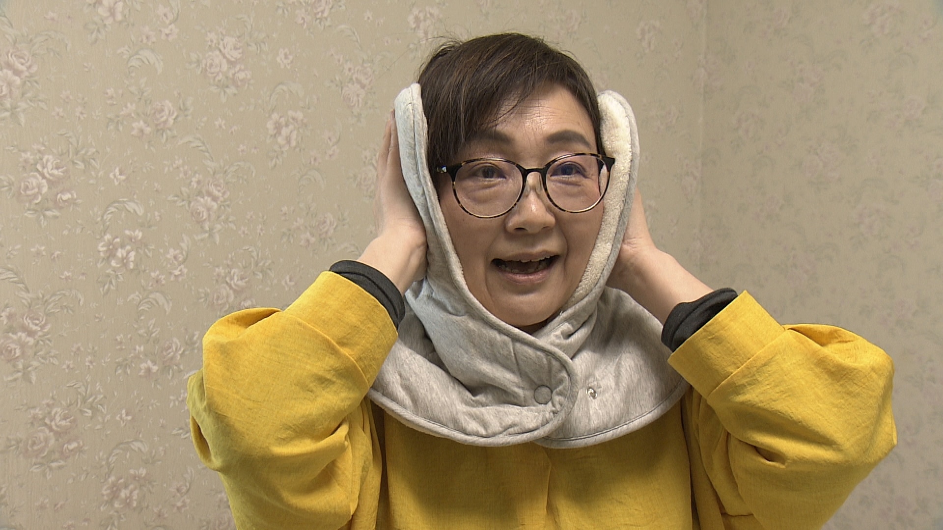 発明品「耳が温まるマフラー」をかぶる松本奈緒美さん